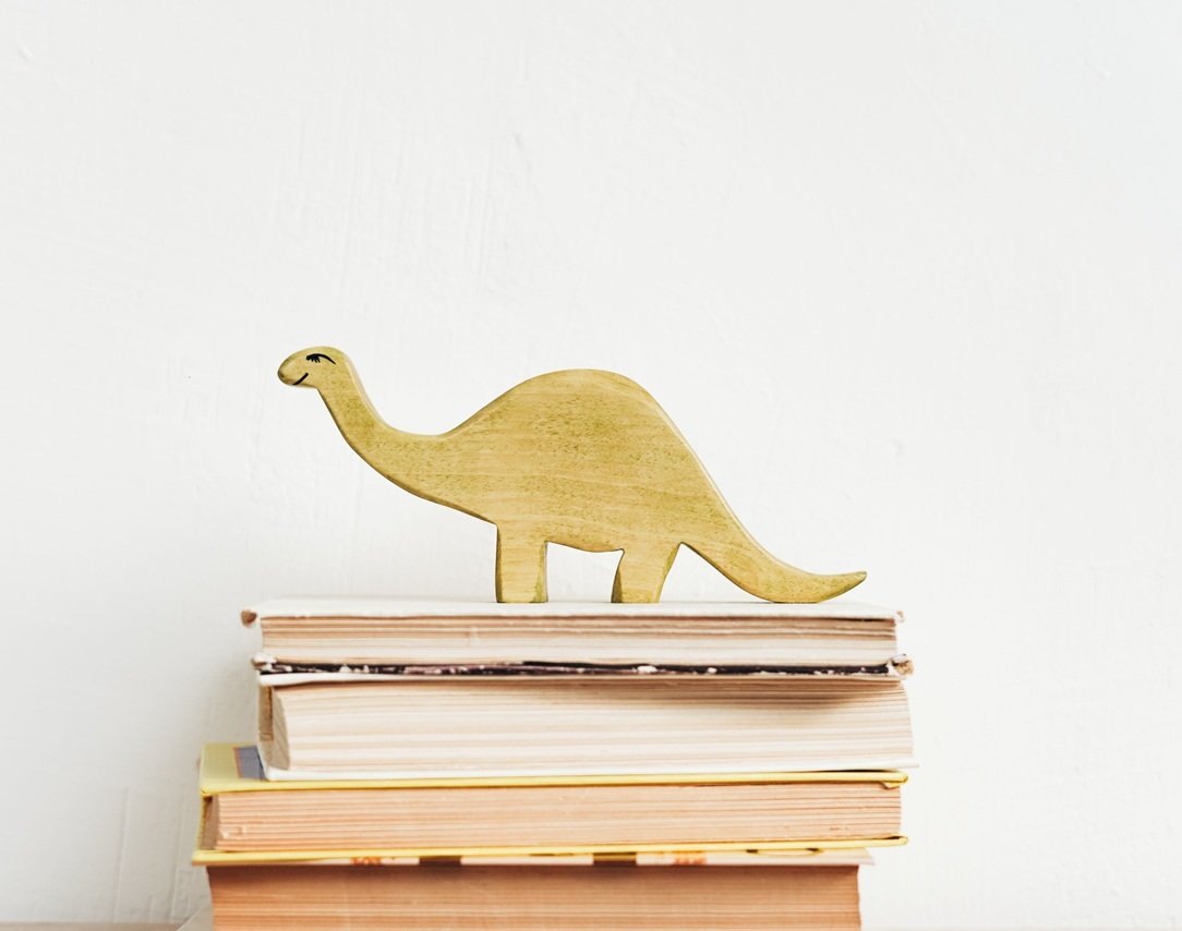 Dinosaur standing on pile of books